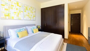 Una camera da letto moderna con un letto grande, un armadio e opere d'arte astratte alle pareti.