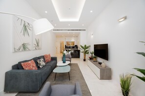 A modern living room with a grey sofa, a coffee table, and a TV.