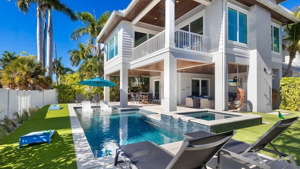 A two-story house with a swimming pool, outdoor seating, and a covered patio area. - Bikini Bottom: 5 Hole Mini Golft, Games,3 Blocks to Beach, Dog Friendly, Pool, by Anna Maria Life (Anna Maria)