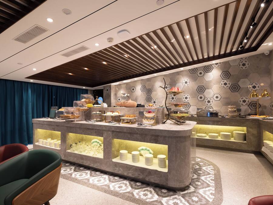 A modern breakfast bar with a variety of food items and a decorative wall with hexagonal patterns.