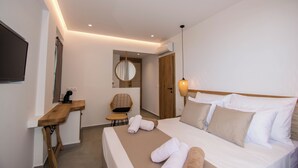 Une chambre d’hôtel moderne, équipée d’un lit, d’une table de chevet, d’une chaise et d’un miroir.