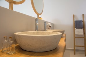A bathroom with a large, round, beige sink and a mirror above it. - Aqua Blu (Hersonissos)