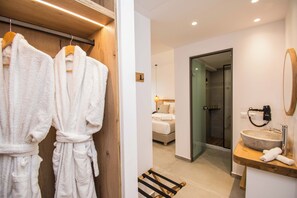 Un baño moderno con tocador de madera, un lavamanos amplio y una cabina de ducha de vidrio.