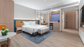Een moderne hotelkamer met een bed, nachtkastje en een bureau met stoel.