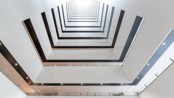 Un interior moderno con una escalera central que desciende a varios niveles.