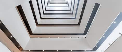 Un interior moderno con una escalera central que desciende a varios niveles.