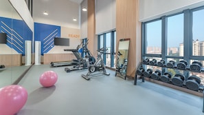 A gym with exercise equipment, a mirror, and a rack of dumbbells. - Holiday Inn Express Shunde Daliang (Foshan)