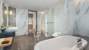 A modern bathroom with a marble floor, a freestanding bathtub, and a large mirror with a curved frame. - Holiday Inn Express Shunde Daliang (Foshan)
