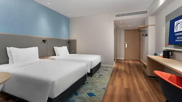 Habitación de hotel con dos camas, un escritorio, una silla, un televisor y una kitchenette.