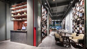 Una biblioteca moderna amb terres de marbre, un taulell de recepció i prestatgeries plenes de llibres.