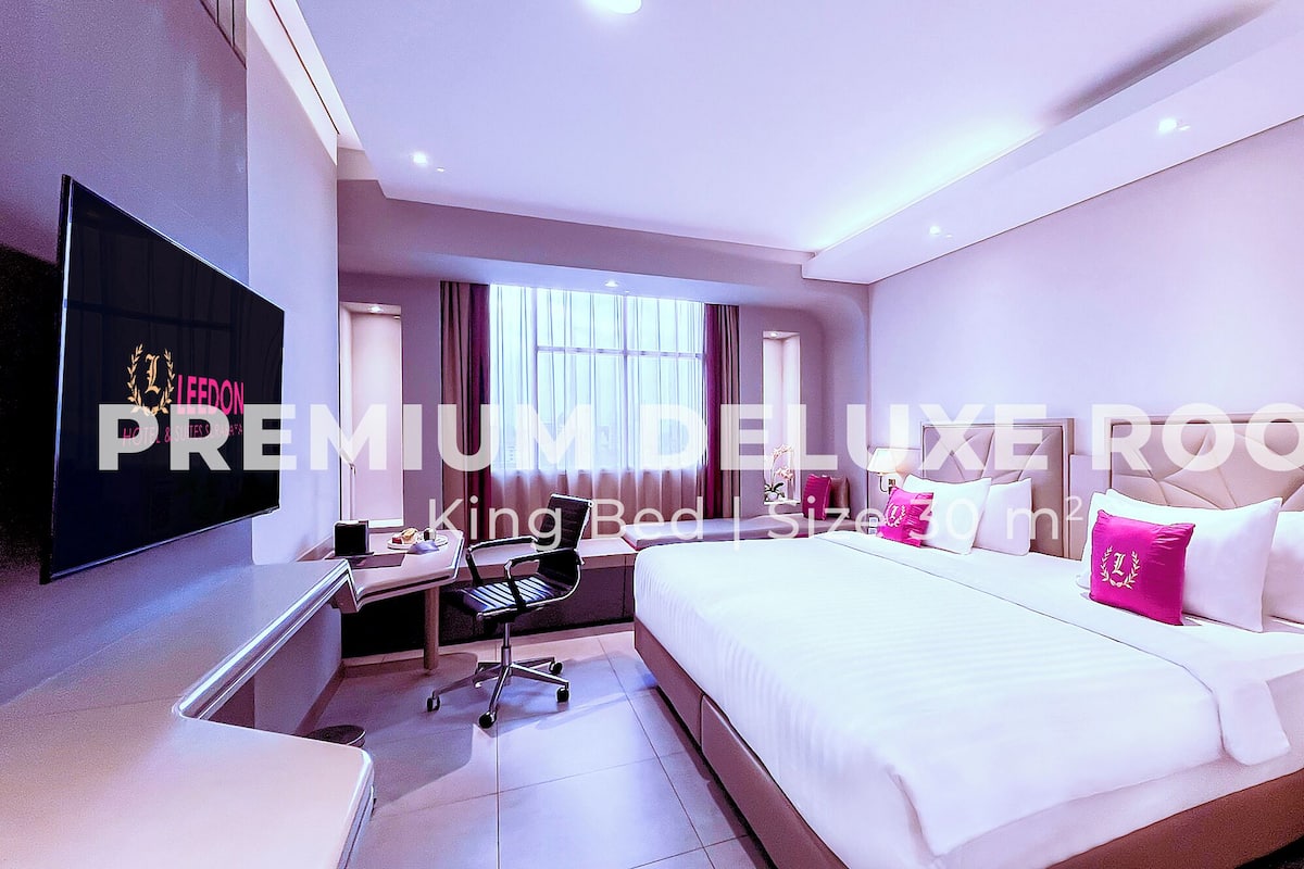 Een moderne hotelkamer met een groot bed, een bureau, een stoel en een flatscreen televisie.