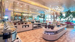 Un restaurant moderne proposant un buffet avec une variété de plats présentés dans différents récipients et une zone centrale pour se servir.