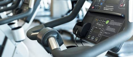 A treadmill with a digital display and control panel.