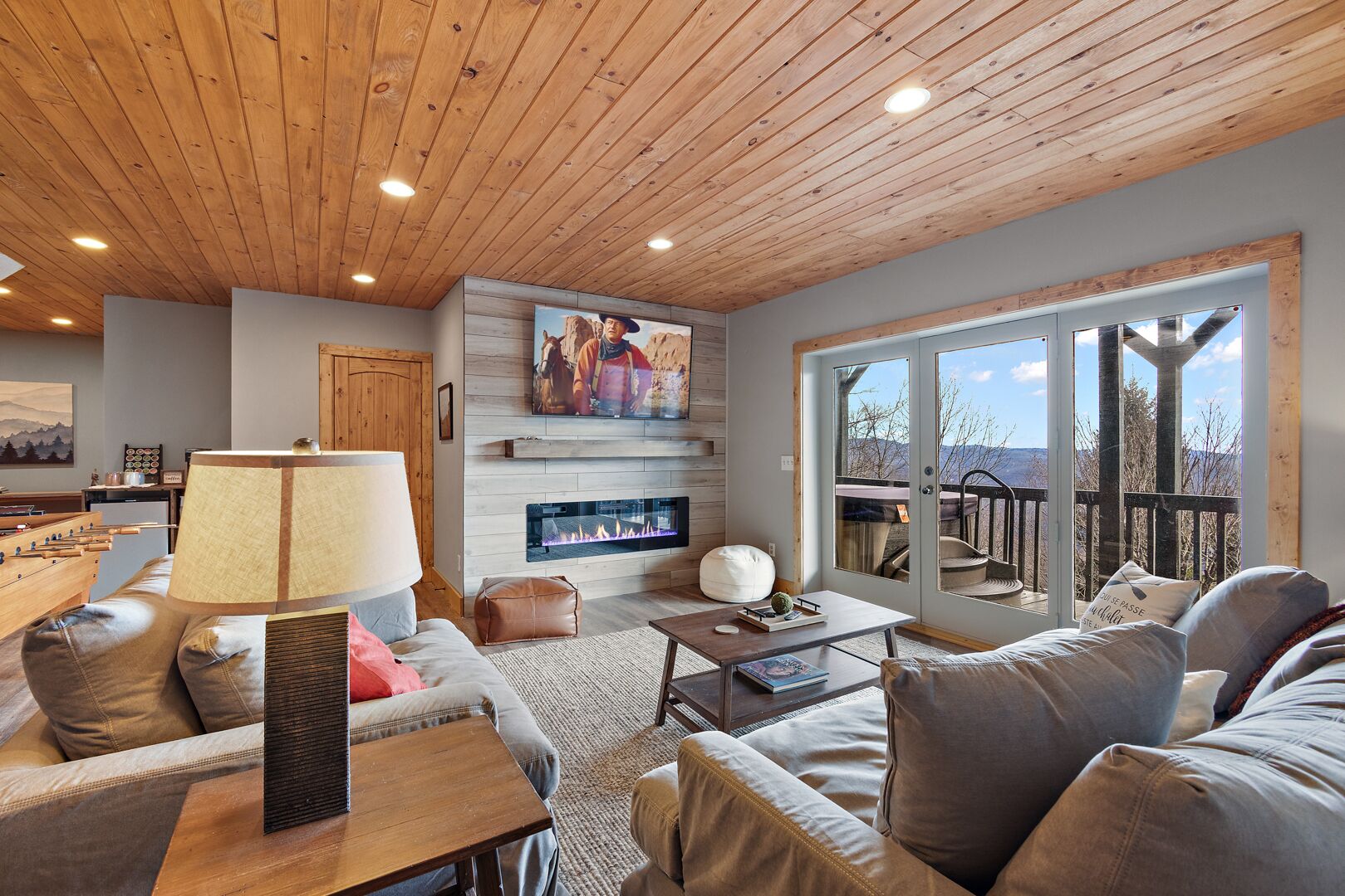 A cozy living room with a fireplace, comfortable seating, and a large window offering a scenic view.