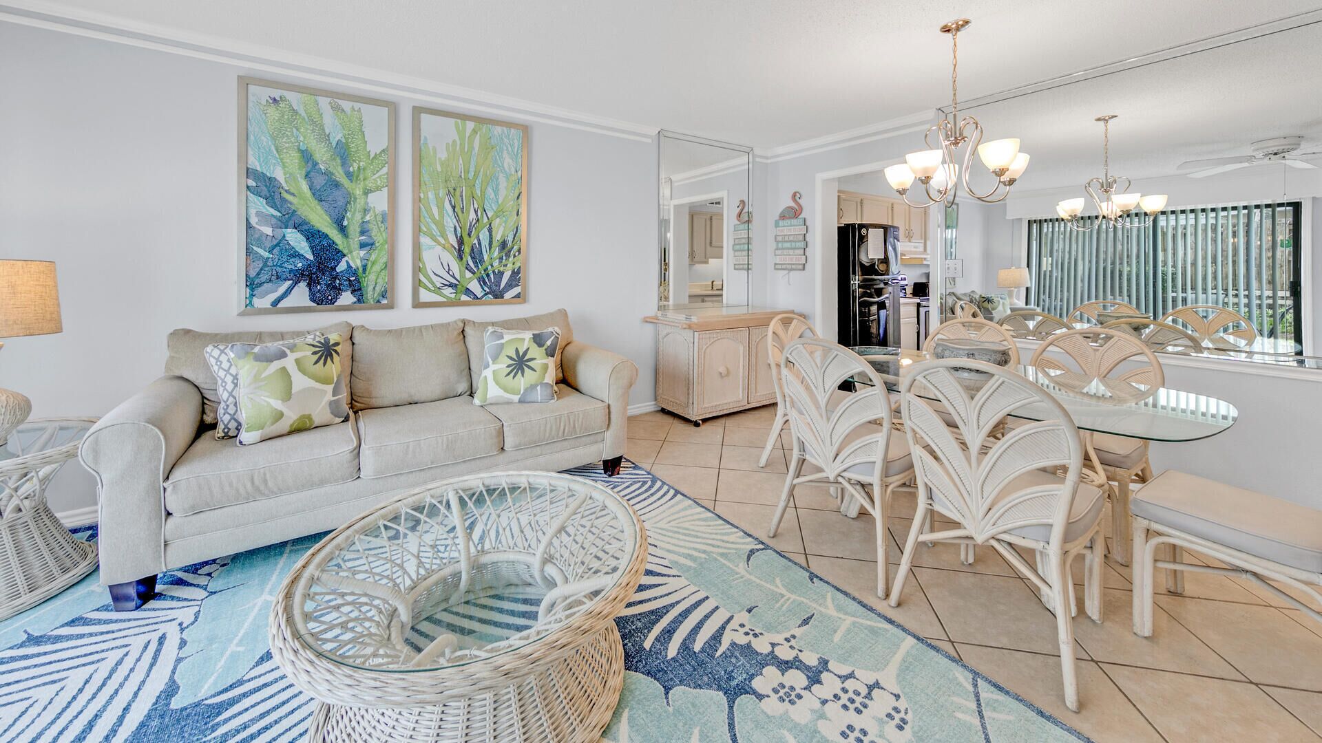 A modern living room with a sofa, a dining table with chairs, and a kitchen in the background.