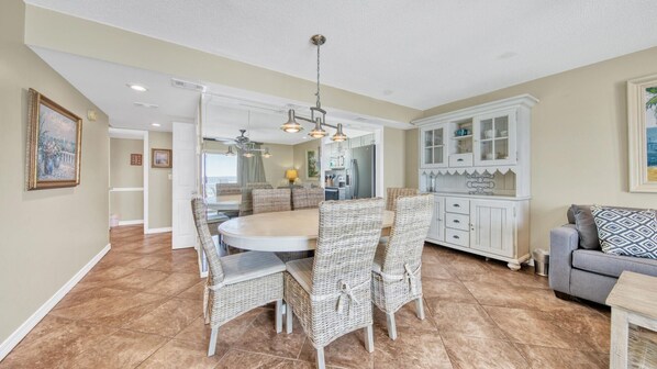 A dining area with wicker chairs, a round table, and a ceiling fan. - Southbay by the Gulf 124 | Beachfront Townhome w/ Pools & Patios (Destin)