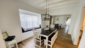 A modern kitchen with a central island, white cabinetry, and a wooden floor.