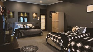 Quarto com cama, mesas de cabeceira, guarda-roupa e espelho.