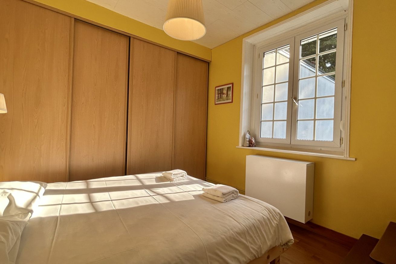 Un dormitorio con cama, ventana y radiador.