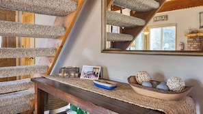A wooden staircase with a textured carpet, a welcome sign, a photo card, and decorative bowls. - 50 Yards to Lake, Boulder Bay Pool Table Lakeside in Bearadise by Avantstay (Big Bear Lake)