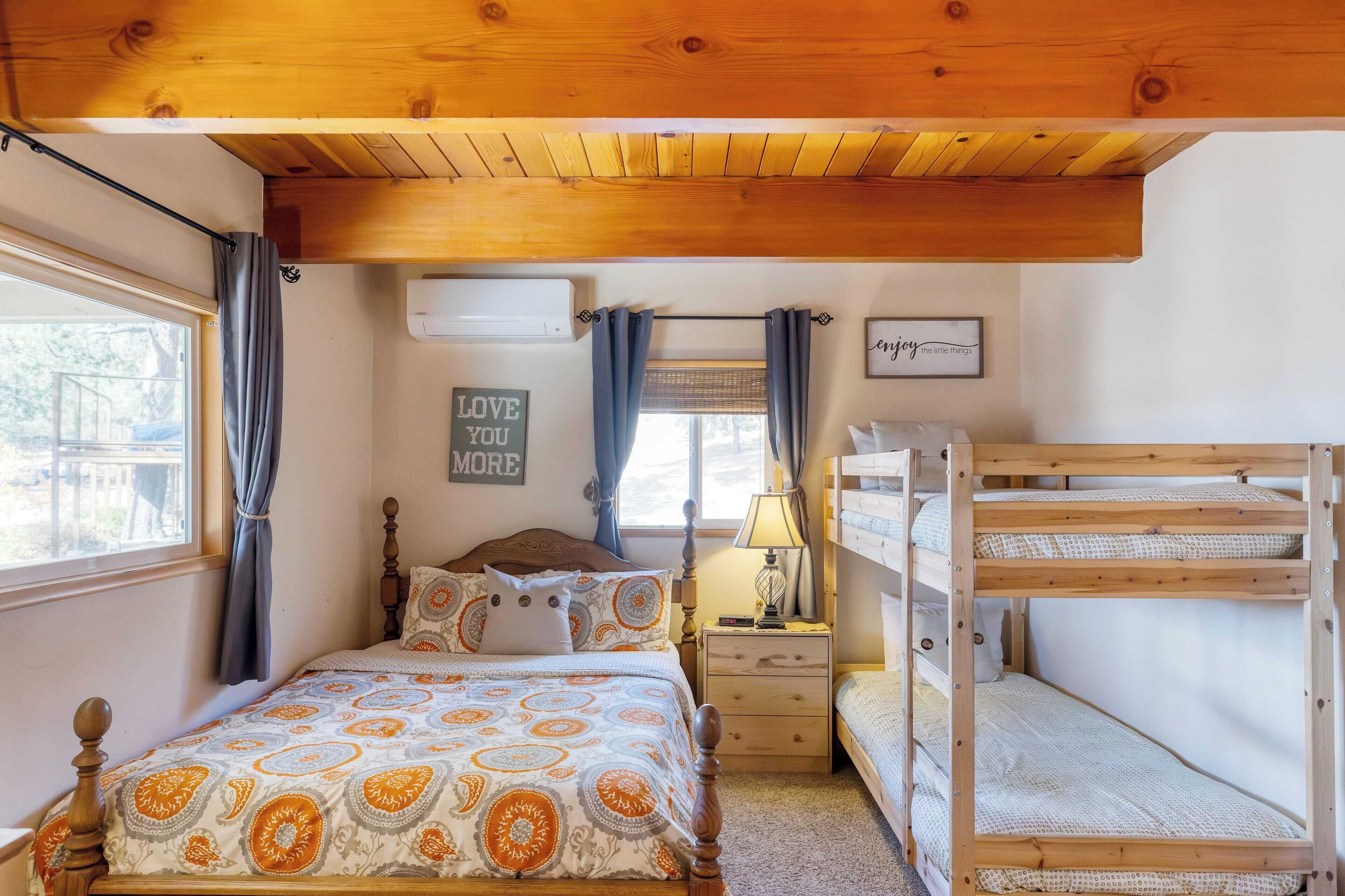 Una camera accogliente con un letto, un comodino, una lampada e un letto a castello.