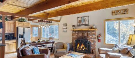 A cozy living room with leather sofas, a fireplace, and a view of the outdoors.