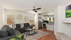 Un salon moderne avec un canapé, une table basse et un ventilateur de plafond.