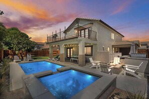 A two-story house with a balcony, a swimming pool, and outdoor seating. - Indio Escape by Avantstay Stunning Home in Coachella w/ Pool & Hot Tub (Indio)