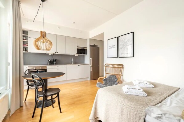 Enjoy a comfortable stay in this stylish room featuring a dining area, kitchenette, and a cozy bed.