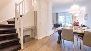 A modern interior with a staircase, a dining area, and a living room. - House Ameland, App. 3 - Modern 3-room apartment with approx. 85m² living space, (Wenningstedt-Braderup (Sylt))