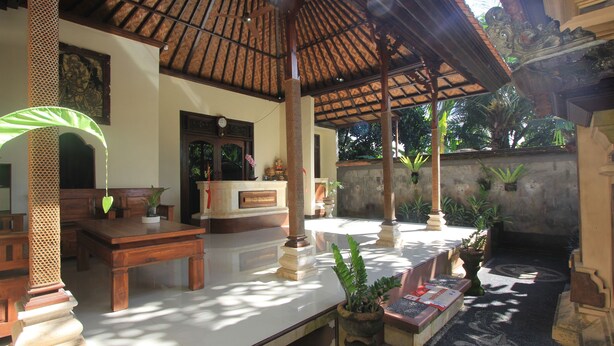 A traditional wooden structure with a tiled floor, a reception desk, and potted plants. - SUARA SIDHI Villa Ubud Bali (Ubud)