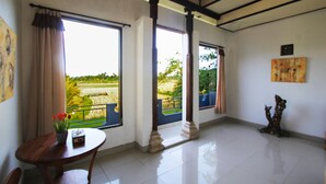 A room with large windows, a dining table with chairs, and a decorative sculpture. - SUARA SIDHI Villa Ubud Bali (Ubud)