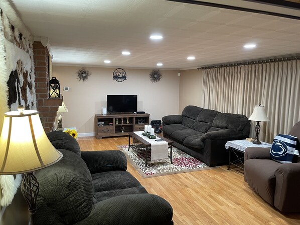 A living room with a fireplace, a television, and a sofa. - Enjoy the best of Central Pennsylvania, Raystown Lake, and Happy Valley. (Huntingdon)