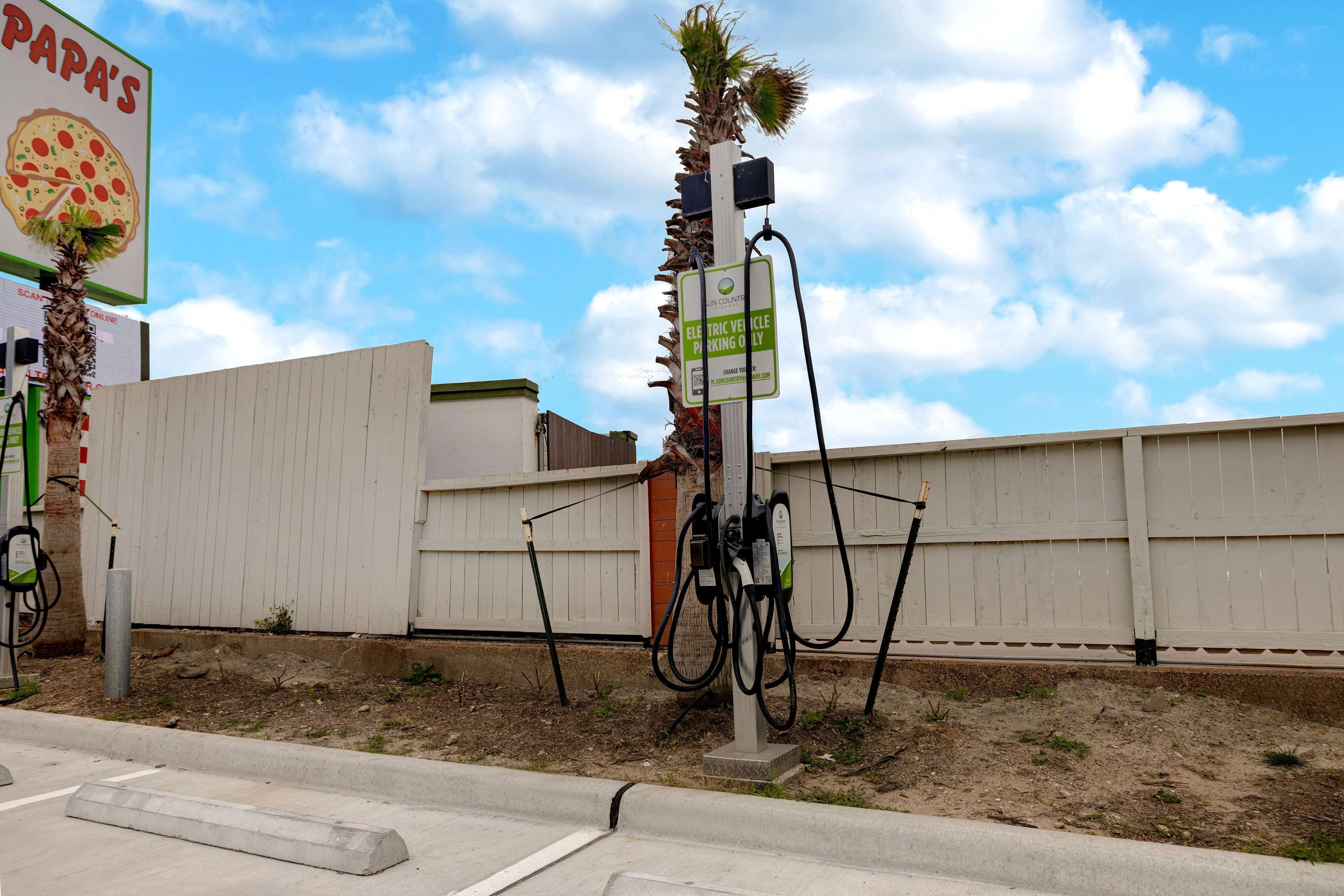 An electric vehicle charging station with a sign indicating it is for electric vehicles only.