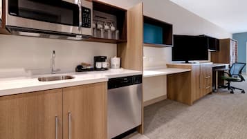 A modern kitchen with stainless steel appliances, a dishwasher, and a coffee maker.