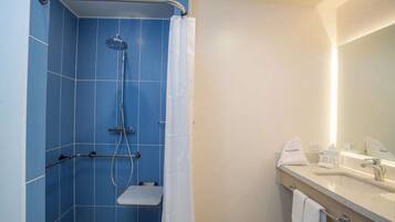 A bathroom with a shower, toilet, and sink.
