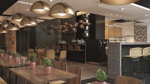 Moderni ravintola, jossa on puupöytiä, -tuoleja ja ruukkukasveja.