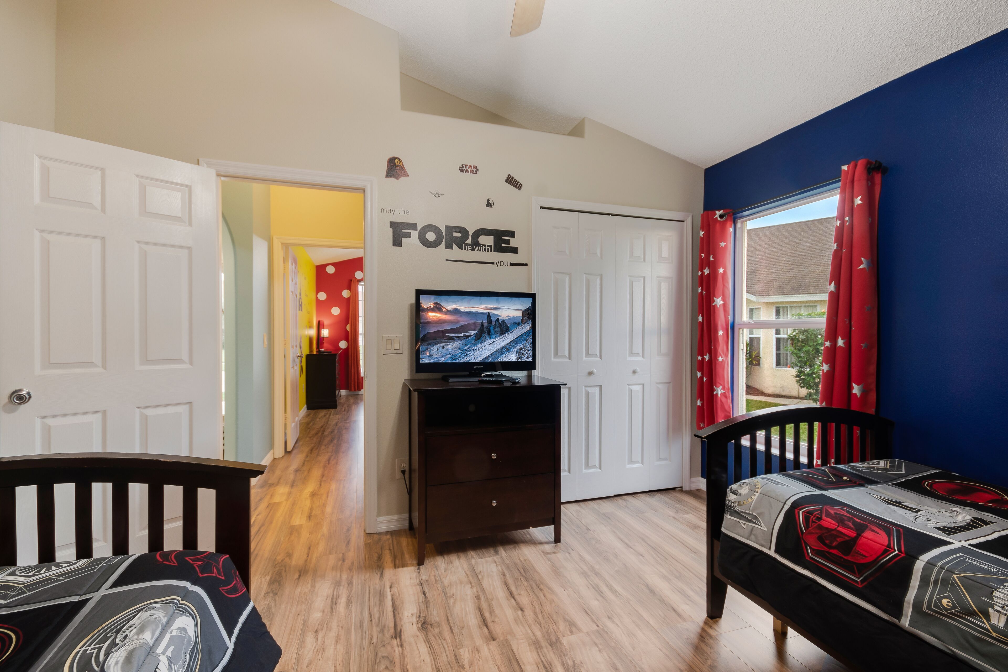 Une chambre à coucher décorée sur le thème de Star Wars, avec des autocollants muraux et du linge de lit assorti.