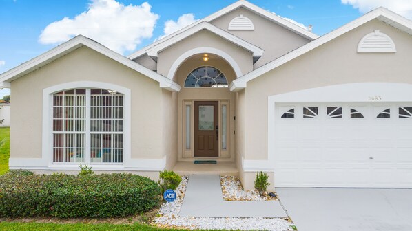 Une maison d’habitation avec un garage, une porte d’entrée et une allée.
