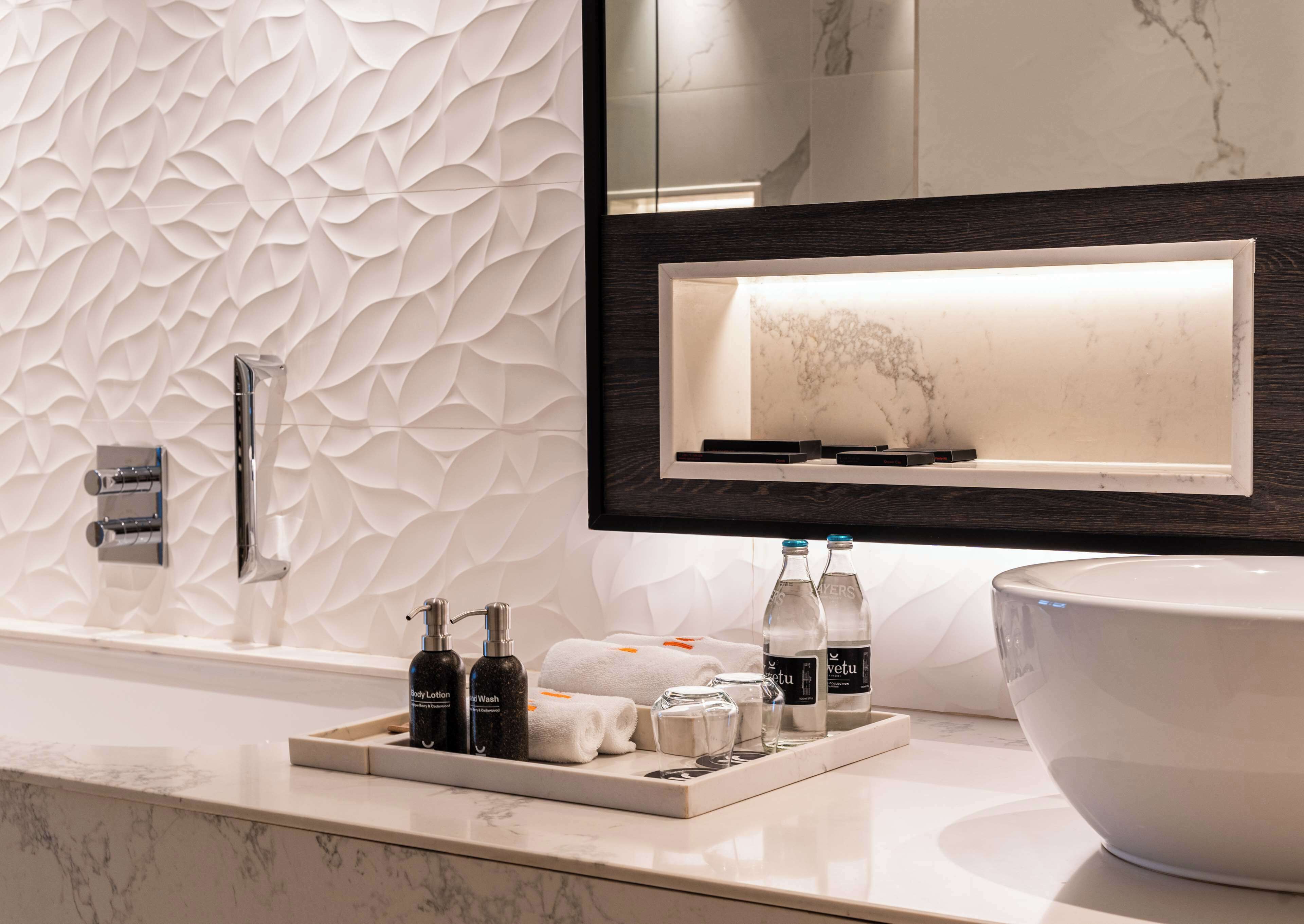 Deep soaking tub, rainfall showerhead, designer toiletries, hair dryer