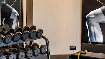 A gym with dumbbells, benches, and exercise equipment.
