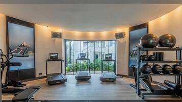A modern gym with treadmills, a rowing machine, and weightlifting equipment.