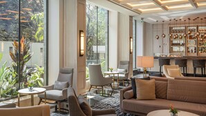 A modern hotel lobby with large windows, a bar area, and comfortable seating. - Kwetu Nairobi, Curio Collection By Hilton (Nairobi)