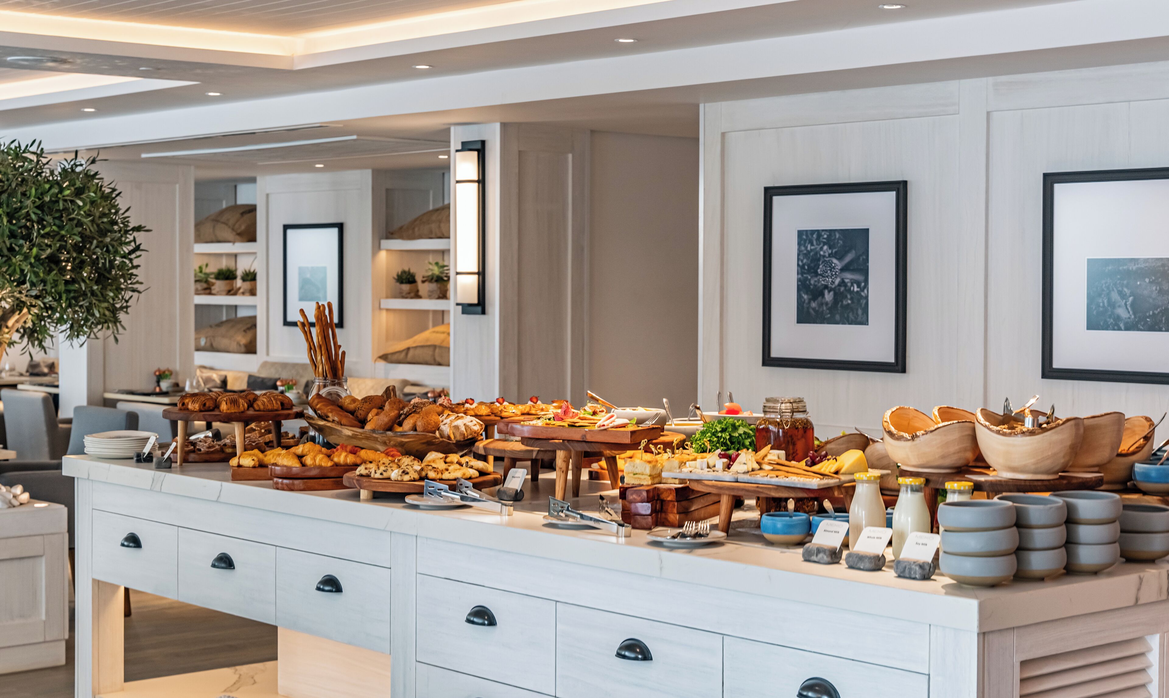 Disposição de buffet com diversos alimentos e utensílios de servir.