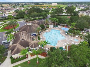 Un quartier résidentiel doté d’une piscine, de palmiers et de maisons.