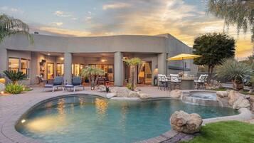 A modern house with a swimming pool, outdoor seating, and a patio area.