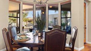 Un coin repas avec une table ronde, des chaises et un lustre.