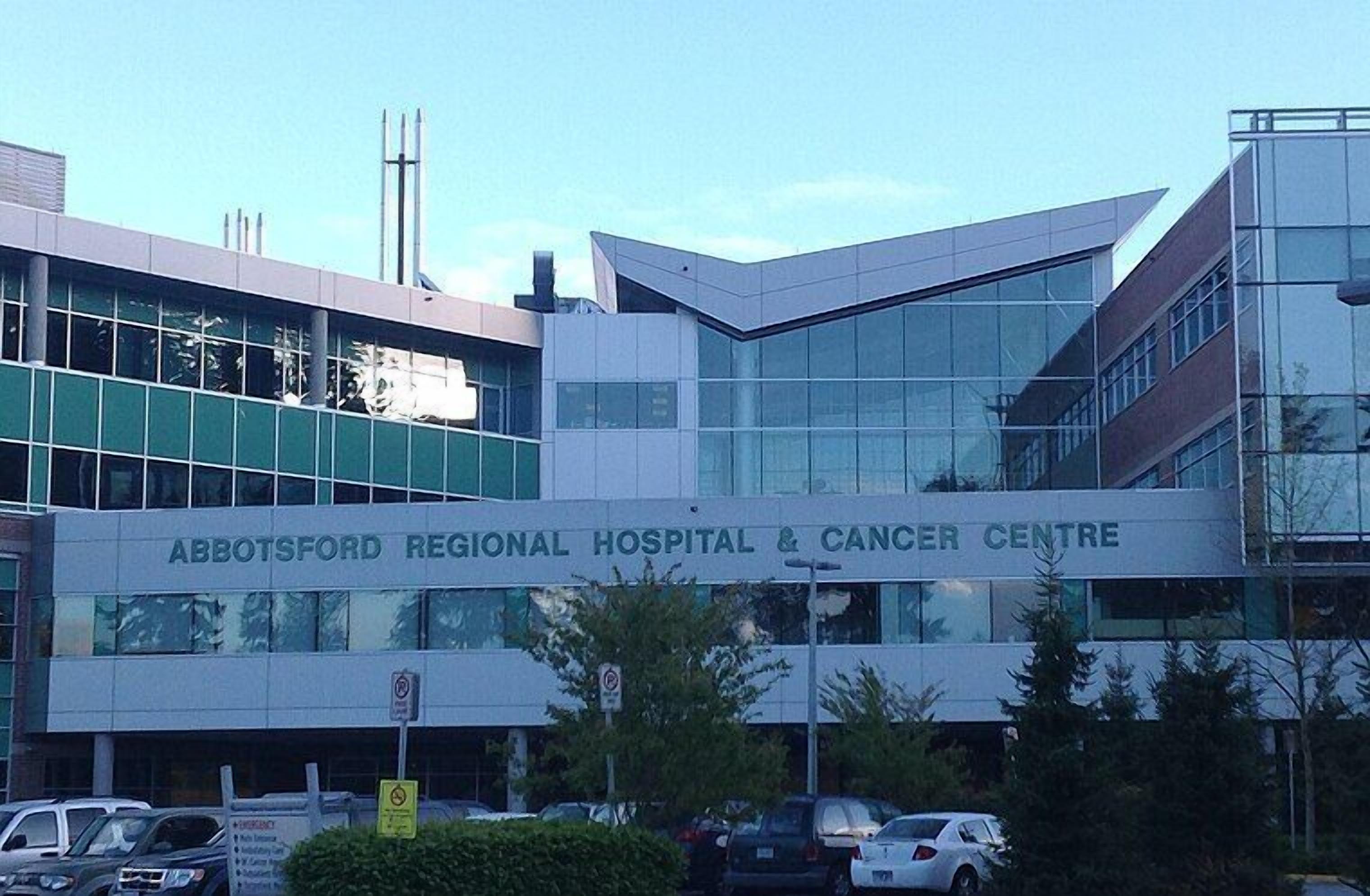The exterior of Abbotsford Regional Hospital & Cancer Centre with a modern architectural design, featuring large glass windows and a prominent signage.