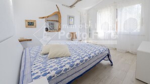 Une chambre à coucher avec un lit, une tête de lit en bois, une petite table et une chaise.
