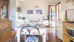 Una cocina acogedora con comedor, armarios de madera y vistas por la puerta.